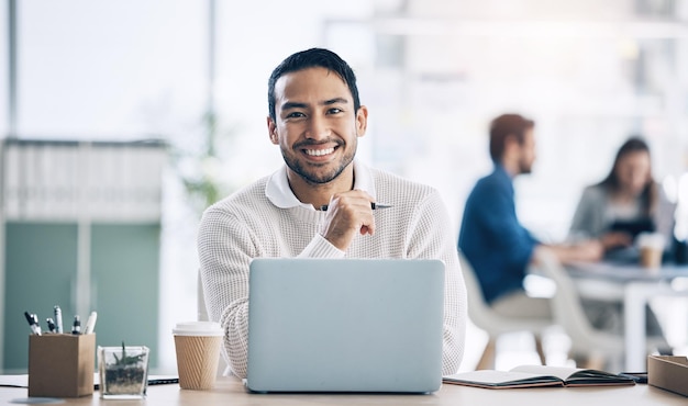 Zakenman laptop en glimlach van Aziatische werknemer in creatief kantoor voor digitaal marketingbeheer en copywriting voor doelgroep van sociale media Portret van ondernemer aan bureau voor online werk