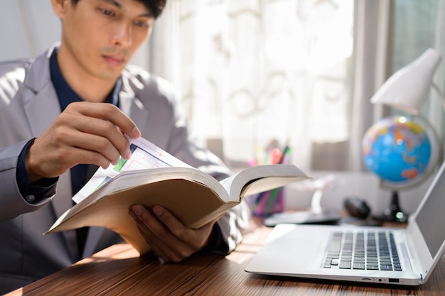 Zakenman leest een boek aan zijn bureau