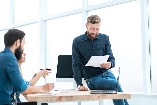 Zakenman leest een document zittend op de tafel. kantoor weekdagen