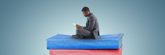 Zakenman lezen op een stapel boeken en grijze achtergrond