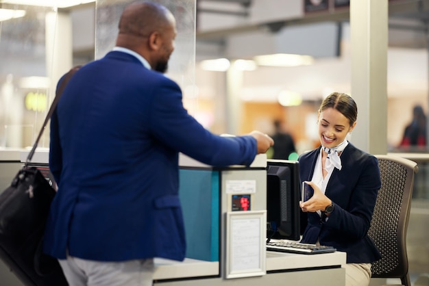 Zakenman luchthaven- en passagiersassistent paspoortdocumenten controleren voor inchecken bij terminalbalie zwarte mannelijke reiziger en serviceagent in reisbeveiliging of immigratie voor luchtvaartcontrole