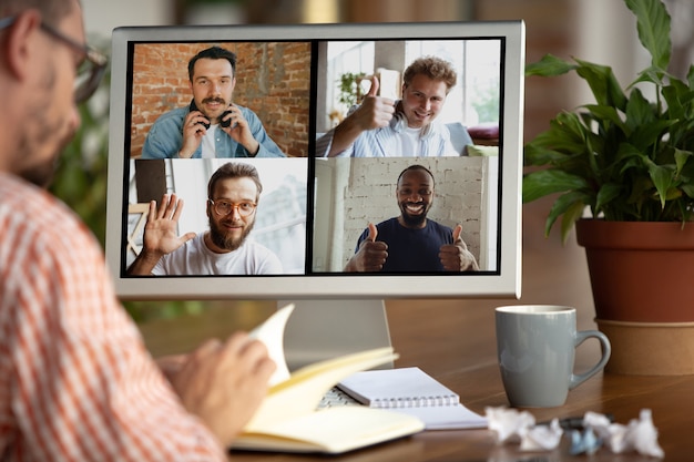 Zakenman, manager voor monitor tijdens online conferentie met collega's en team. Thuiswerken tijdens coronavirus of COVID-19 quarantaine