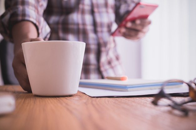 Zakenman met behulp van smartphone en koffie drinken.