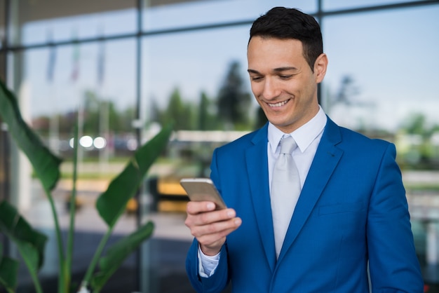 Zakenman met behulp van zijn mobiele telefoon