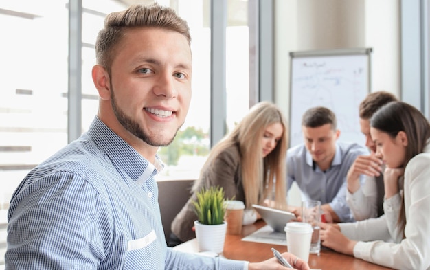 Zakenman met collega's op de achtergrond in kantoor