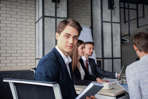 Zakenman met collega's op de achtergrond op kantoor.