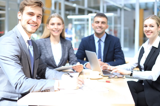 Zakenman met collega's op de achtergrond op kantoor.