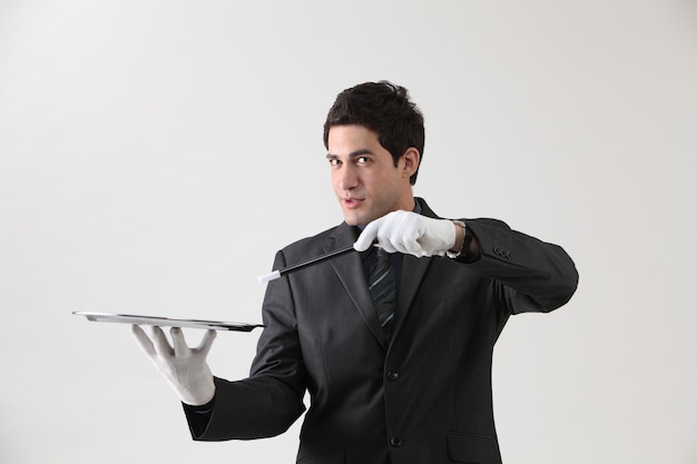Foto zakenman met een bord en een toverstok op een grijze achtergrond