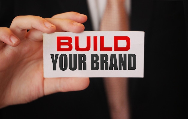 Foto zakenman met een kaart met tekst build your brand business opstarten marketingconcept