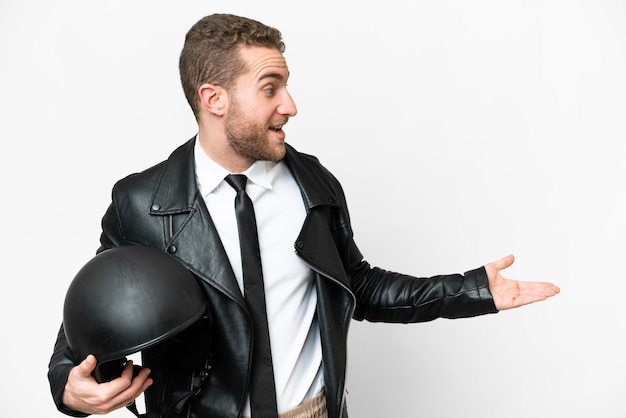 Zakenman met een motorhelm over een geïsoleerde witte achtergrond met een verbaasde uitdrukking terwijl hij naar de zijkant kijkt