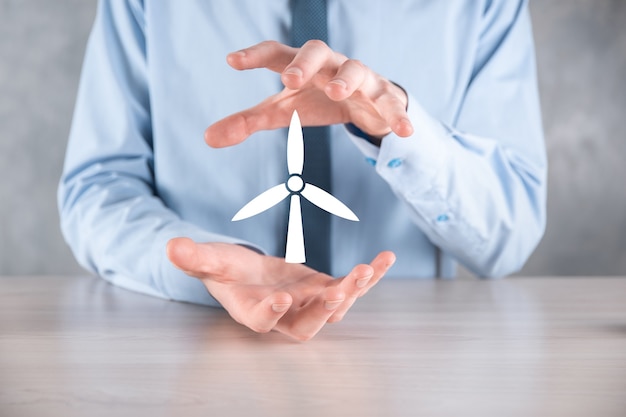 Zakenman met een pictogram van een windmolen die milieu-energie produceert