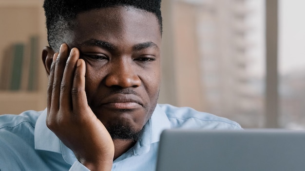 zakenman met slaapproblemen op het werk voelt zich moe van online werk aan de computer