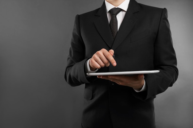 Zakenman met tablet op grijze achtergrond