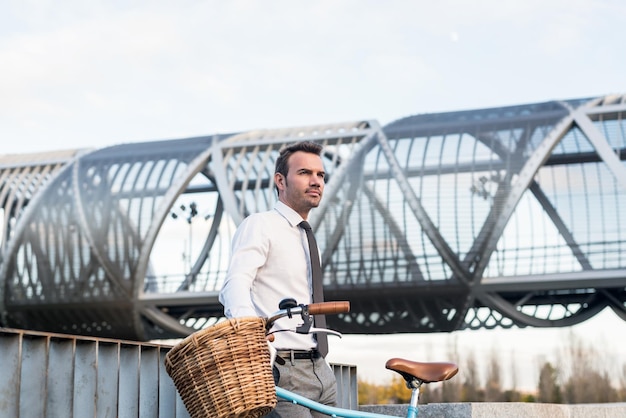 Zakenman met vintage fiets bij de rivier