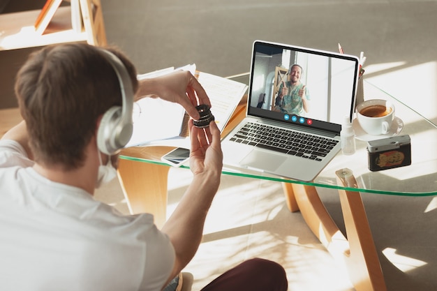 Foto zakenman neemt deel aan videoconferentie en kijkt naar laptopscherm tijdens virtuele vergadering, videocall webcam-app voor bedrijven, close-up. werken op afstand, freelance, onderwijs, lifestyle concept.