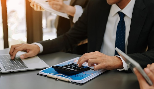 Zakenman of accountant die laptop met de hand typt om op het bureau te berekenen over de kosten op kantoor aan huis