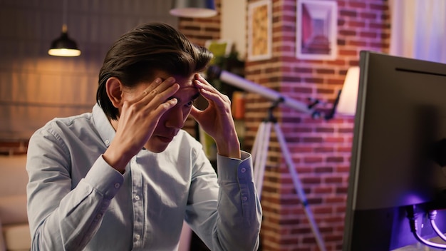 Zakenman omgaan met hoofdpijn en migraine bij externe baan, thuiswerken en lijden aan burn-out en stress. Overwerkt en gefrustreerd voelen, computer gebruiken. .