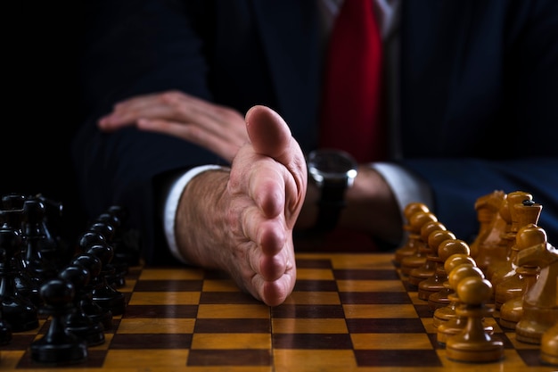 zakenman op het schaakbord, hand scheidt witte en zwarte stukken