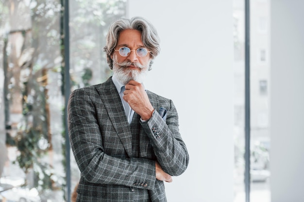 Zakenman op kantoor Senior stijlvolle moderne man met grijs haar en baard binnenshuis