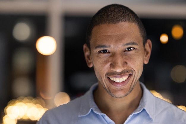Zakenman portret glimlach en bedrijfsmedewerker klaar voor financieel en boekhoudkundig werk 's nachts Bedrijfsvisie en geluk van een zwarte man glimlach over financiële groei in een modern kantoor