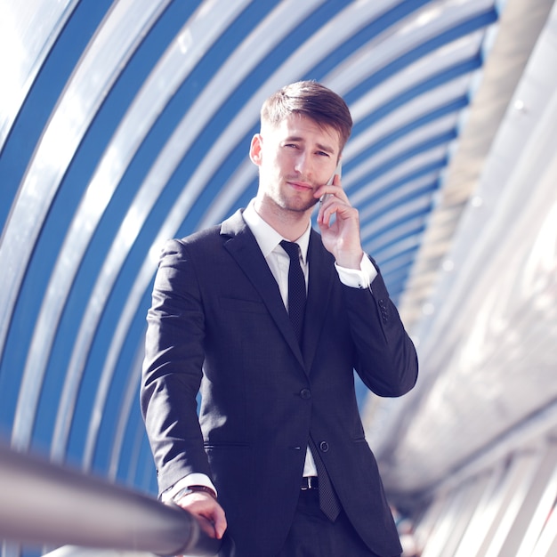 Zakenman praten aan de telefoon in een modern gebouw