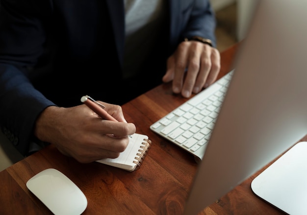 Zakenman schrijven in een notitieblok op zijn bureau