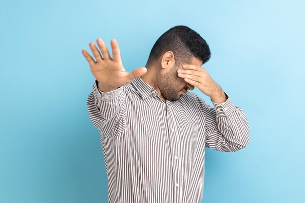 Zakenman sluit de ogen met een handpalm die een andere hand naar voren uitstrekt en de ruimte aanraakt