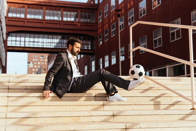 Zakenman spelen met een voetbal en het maken van freestyle trucs