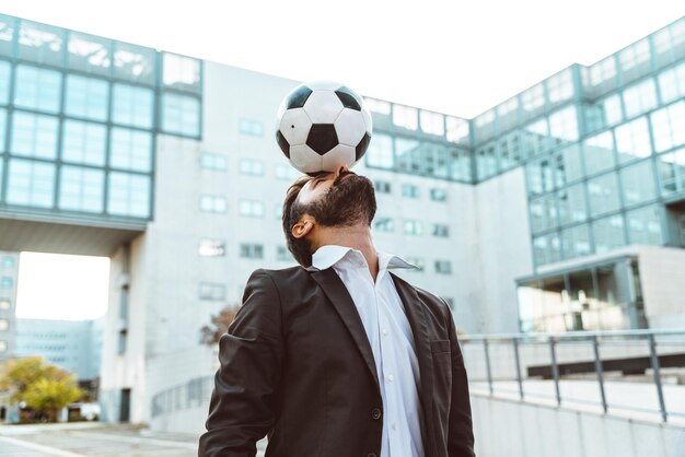 Zakenman spelen met een voetbal en het maken van freestyle trucs