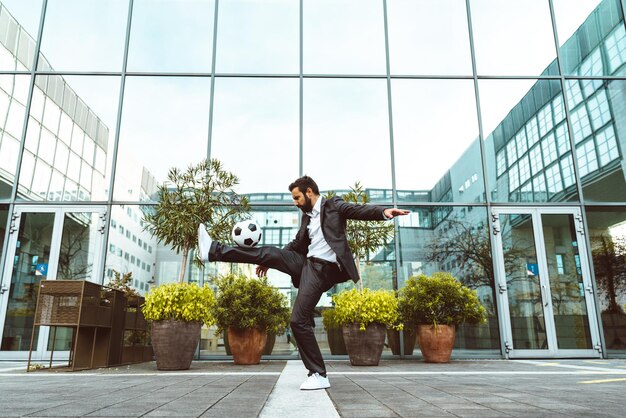 Zakenman spelen met een voetbal en het maken van freestyle trucs