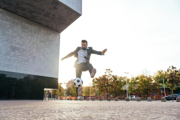 Zakenman spelen met een voetbal en het maken van freestyle trucs