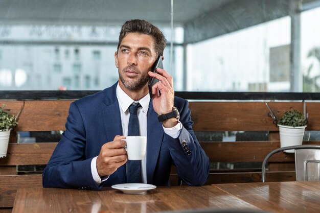 Zakenman spreken op smartphone in café