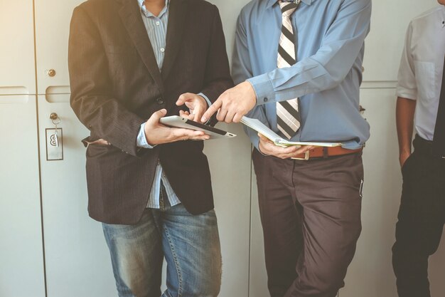 Zakenman, staand, klesten Mensen uit het bedrijfsleven met behulp van een digitale tablet.