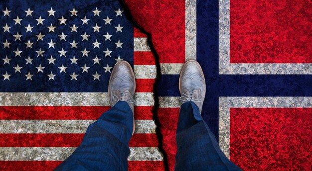 Zakenman staat op gebarsten vlaggen van de VS en Noorwegen Politiek concept