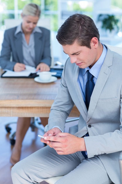 Zakenman texting op zijn mobiele telefoon