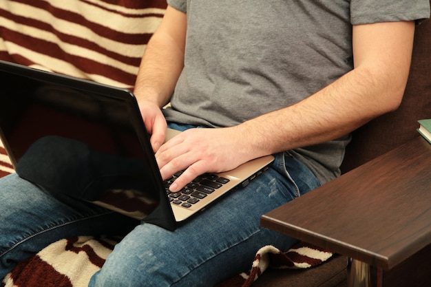 Zakenman thuis werken met een laptop op de bank