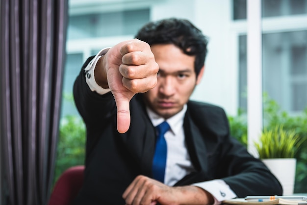 Zakenman verdrietig duimen naar beneden tonen, focus hand