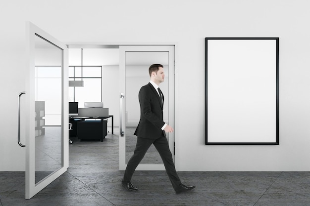 Zakenman wandelen in kantoor interieur met embty banner op muur