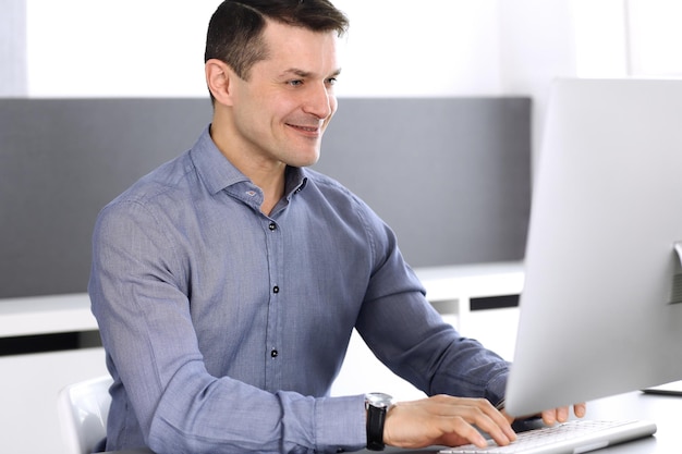 Zakenman werken met computer in moderne kantoren. headshot van mannelijke ondernemer of bedrijfsleider op de werkplek. bedrijfsconcept.