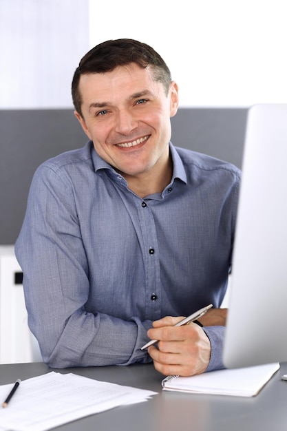 Zakenman werken met computer in moderne kantoren. headshot van mannelijke ondernemer of bedrijfsleider op de werkplek. bedrijfsconcept.