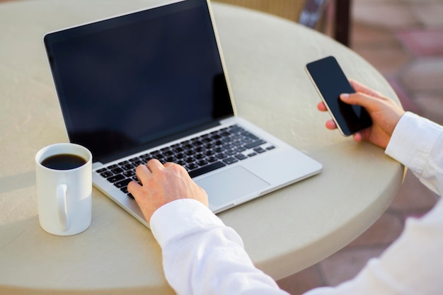 Zakenman werken met mobiele telefoon en laptop en kopje koffie