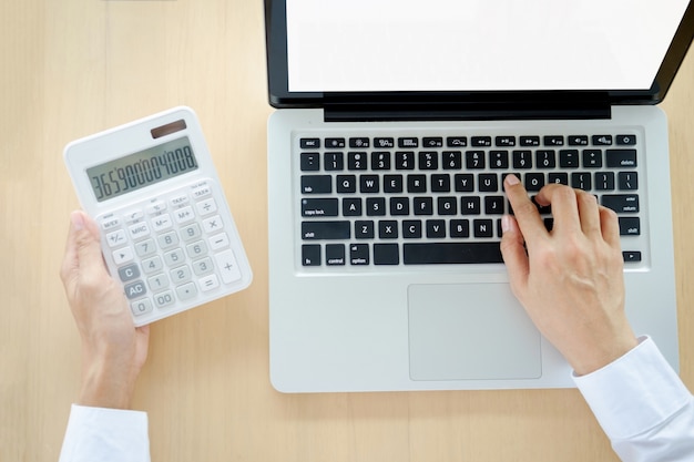 Zakenman werken op een computer en vindt de rekenmachine n de kantoor werkplek