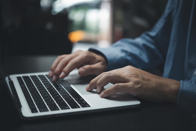 Zakenman werkt door te typen op het toetsenbord van de laptop op kantoor Zakelijke internet digitale technologie online