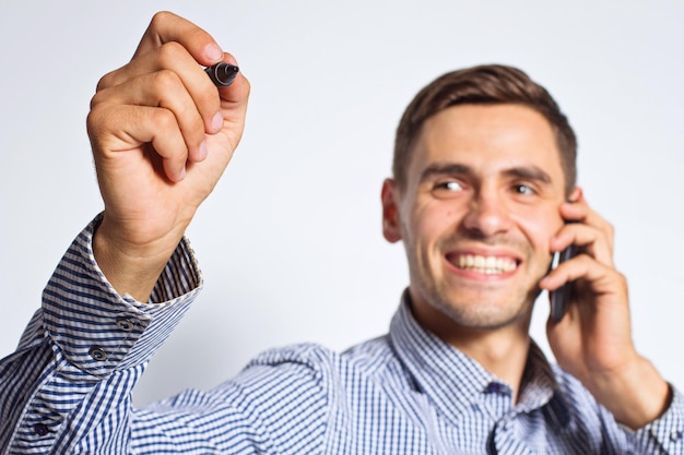 Zakenman wijzen iets met marker en mobiele telefoon op witte achtergrond