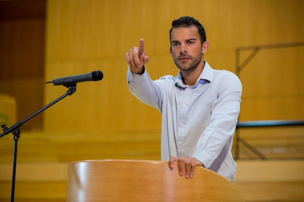 Foto zakenman wijzen terwijl het houden van een toespraak op conferentiecentrum