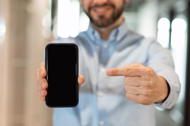 Zakenman wijzend op zwart leeg smartphonescherm