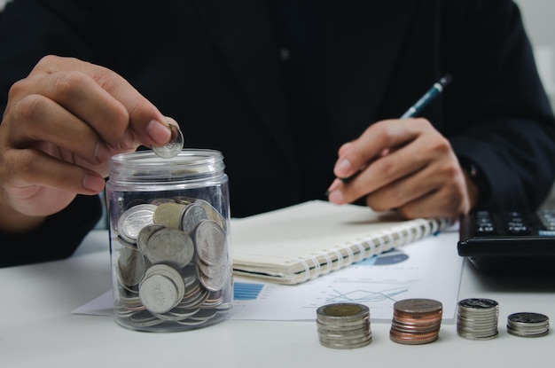 Zakenman wordt getoond met een pot met munten voor sparen en beleggen Concept van belastingbetalingen en zakelijke boekhouding