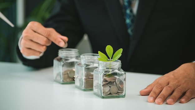 Zakenman zet munt om geld te besparen glazen pot gyre