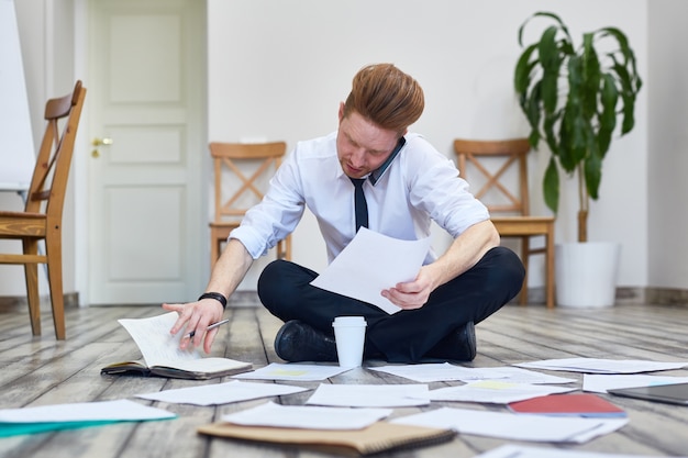 Zakenman zittend op de vloer in Office werken