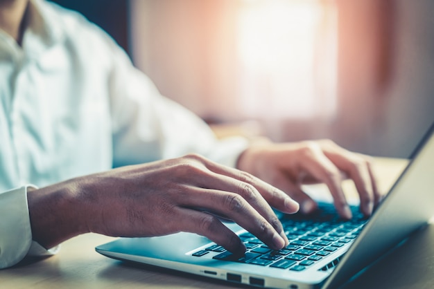 Zakenmanhand die laptop computer in bureau met behulp van.